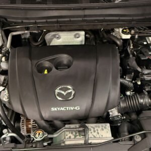 Khoang máy Mazda CX-5 sau khi vệ sinh tại QC Auto, nắp che động cơ đen đều màu, sạch bụi dầu